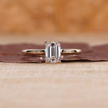 Emerald solitaire engagement ring with a classic design.
