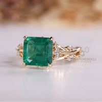 Cluster engagement ring with emerald center stone.
