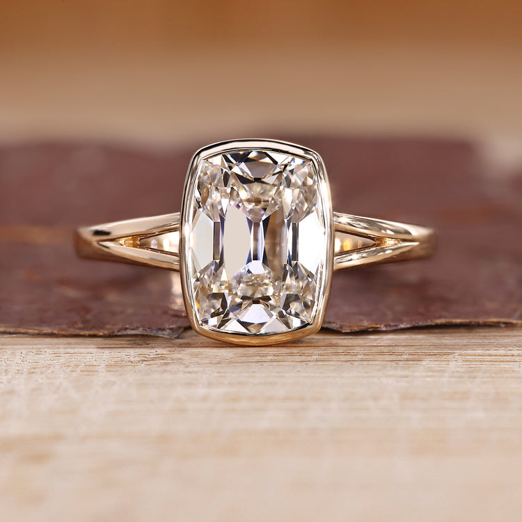 Bezel set diamond ring with cushion old mine cut diamond in solitaire setting.