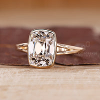Cushion old mine cut diamond ring in bezel solitaire design.