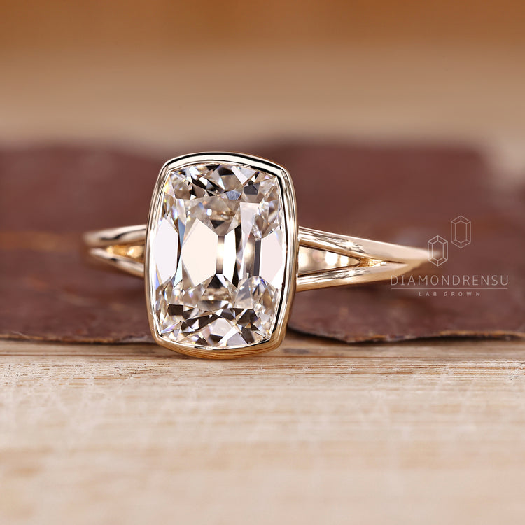 Cushion old mine cut diamond ring in bezel solitaire design.