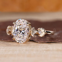 Custom diamond ring with oval center and side stone accents.

