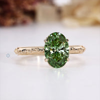 Green oval engagement ring with a four claw prong setting.