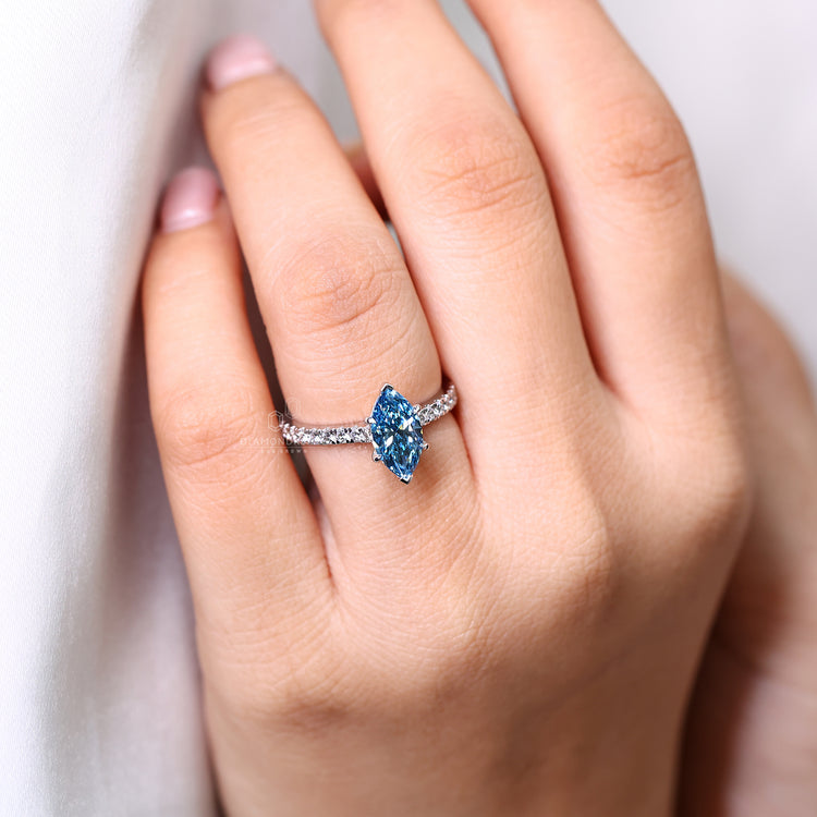 Pave setting ring with marquise cut blue diamond and cathedral setting.
