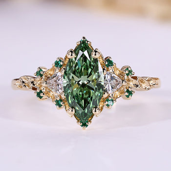 Green marquise engagement ring with trillion side stones and emerald gemstone.