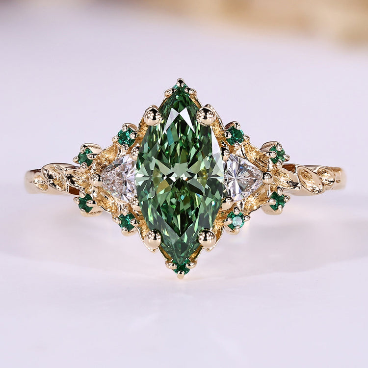Green marquise engagement ring with trillion side stones and emerald gemstone.