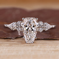 Coffin cut engagement ring with kite and round side stones.