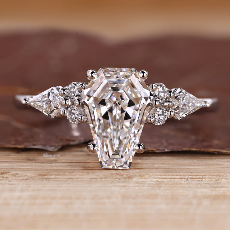 Coffin cut engagement ring with kite and round side stones.
