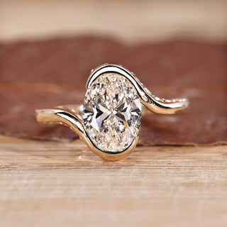 Oval cut diamond ring with half bezel and hidden pavé setting.
