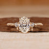 Three diamond ring with oval centre and round side diamonds.
