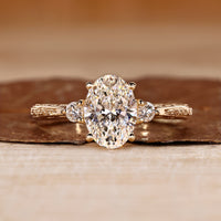 Three diamond ring with oval centre and round side diamonds.