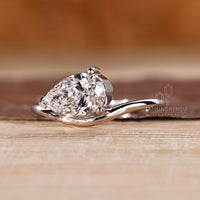 Custom pear diamond solitaire engagement ring set in elegant white gold.
