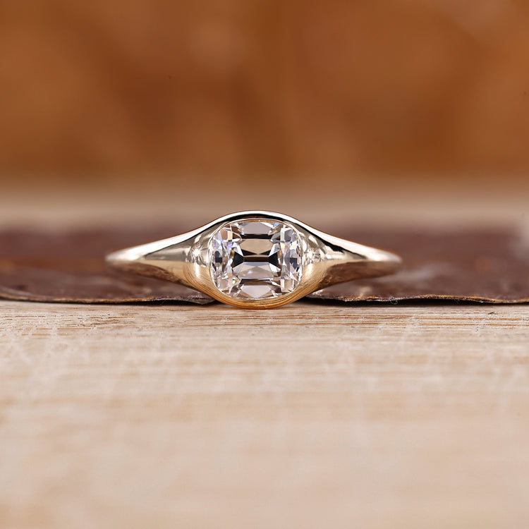 Old mine cushion cut diamond ring in east to west solitaire setting.
