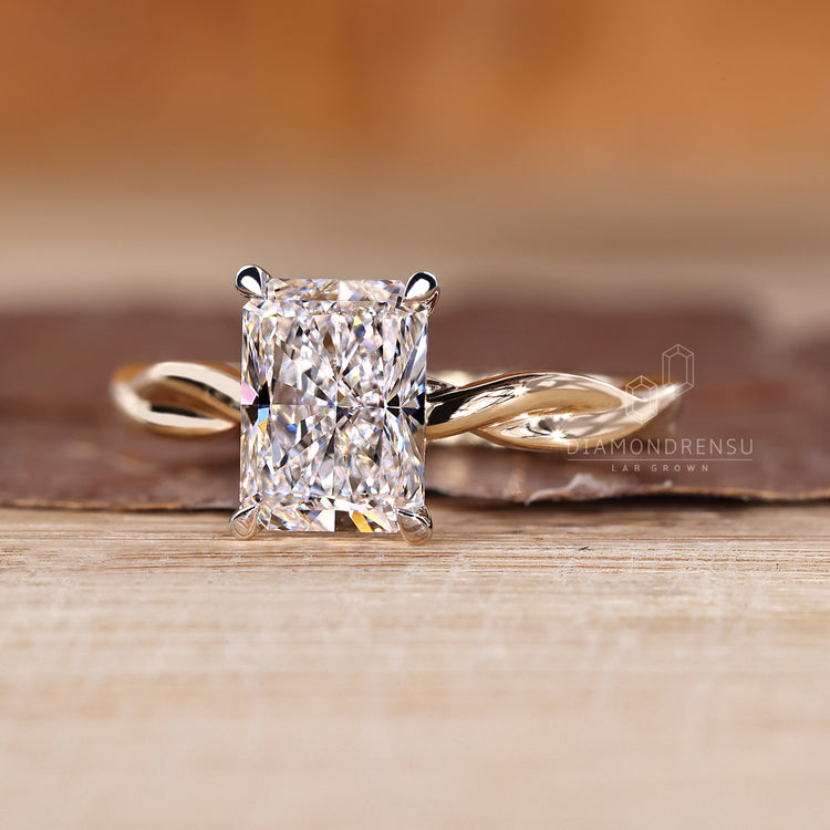 Yellow and white gold twisted shank ring with radiant cut diamond.
