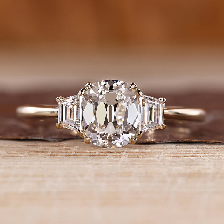 Old mine cushion cut diamond with trapezoid side stones.