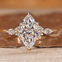 Marquise diamond ring with marquise and round side stones and muse setting.