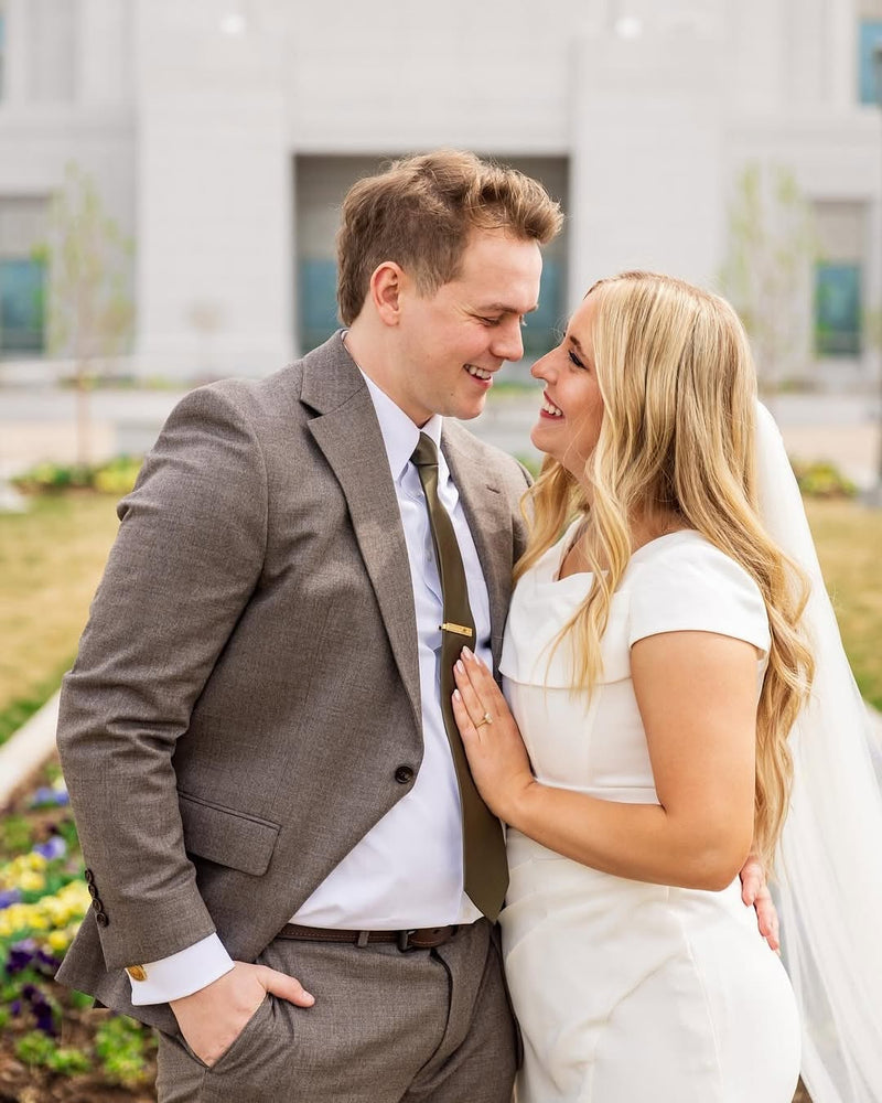 Newlyweds in a grey tweed wedding suit and white bridal dress