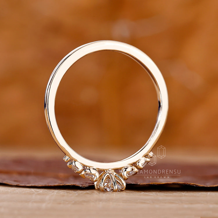Diamondrensu engagement ring with oval cut diamond and round side stones.
