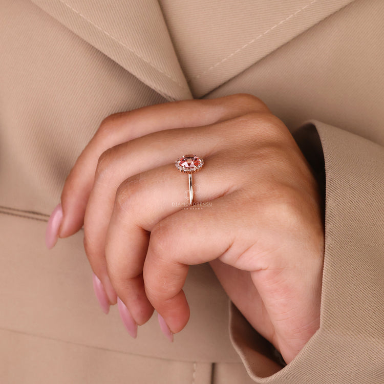 Halo Ring featuring a brilliant pink diamond centerpiece.