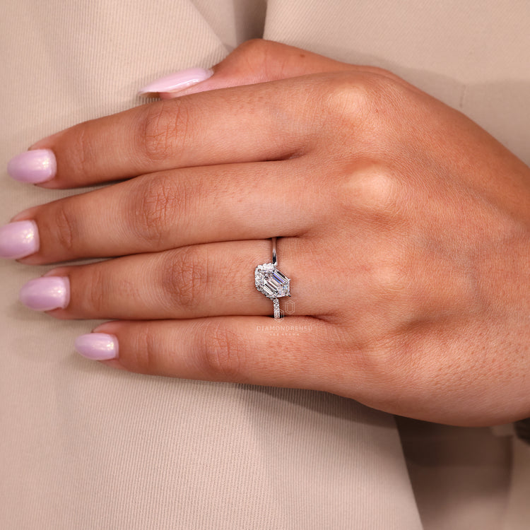 Unique halo setting ring with round side stones and white gold band.