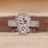 Coffin cut engagement ring with round cut halo and double band.