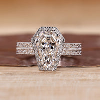 Coffin cut engagement ring with round cut halo and double band.