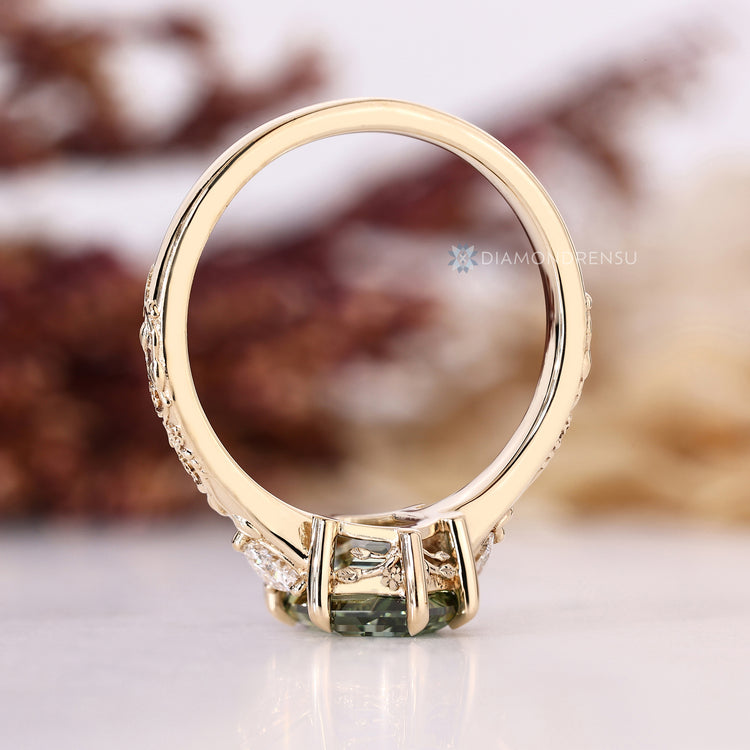 Green hexagon shape diamond ring with trillion side stones.