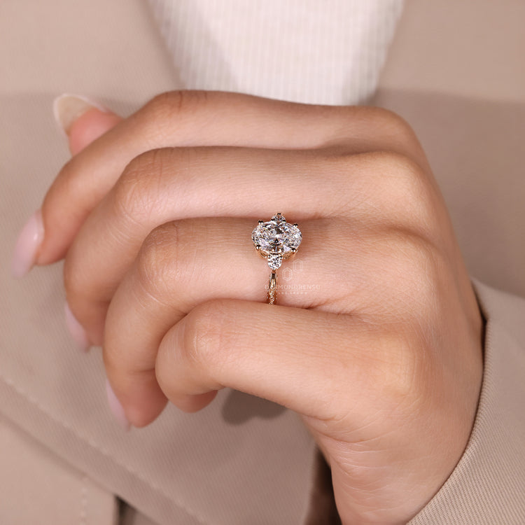 Tapered shank ring with oval diamond and round side stones.