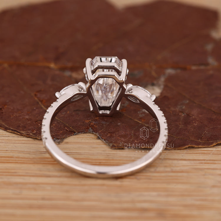 Handmade coffin ring with four prongs and side stone accents.