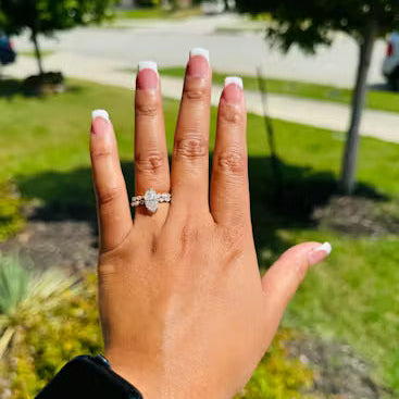 Hand showing an engagement ring outdoors