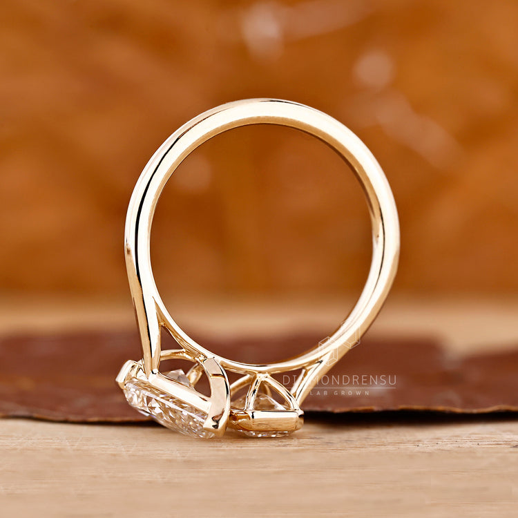 Unique toi et moi ring pear emerald bezel cathedral setting.