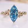 Blue marquise engagement ring with round side stones.