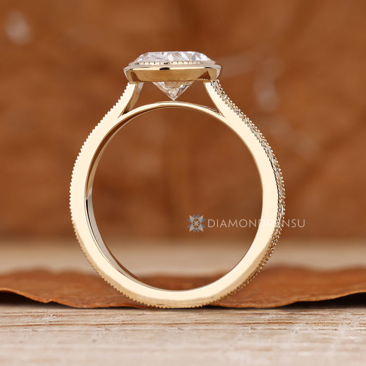 Oval diamond ring with bezel and cathedral setting.