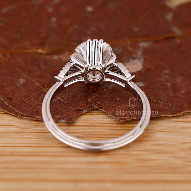 Cushion old mine diamond with knife edge shank and fishtails prongs.
