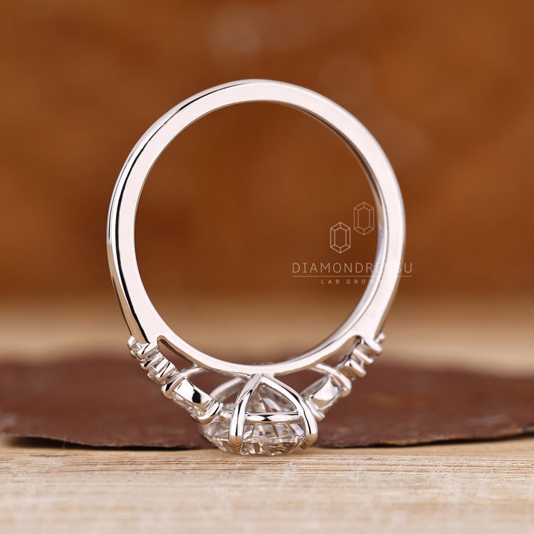Oval cut ring with seven stones featuring lab grown center diamond.