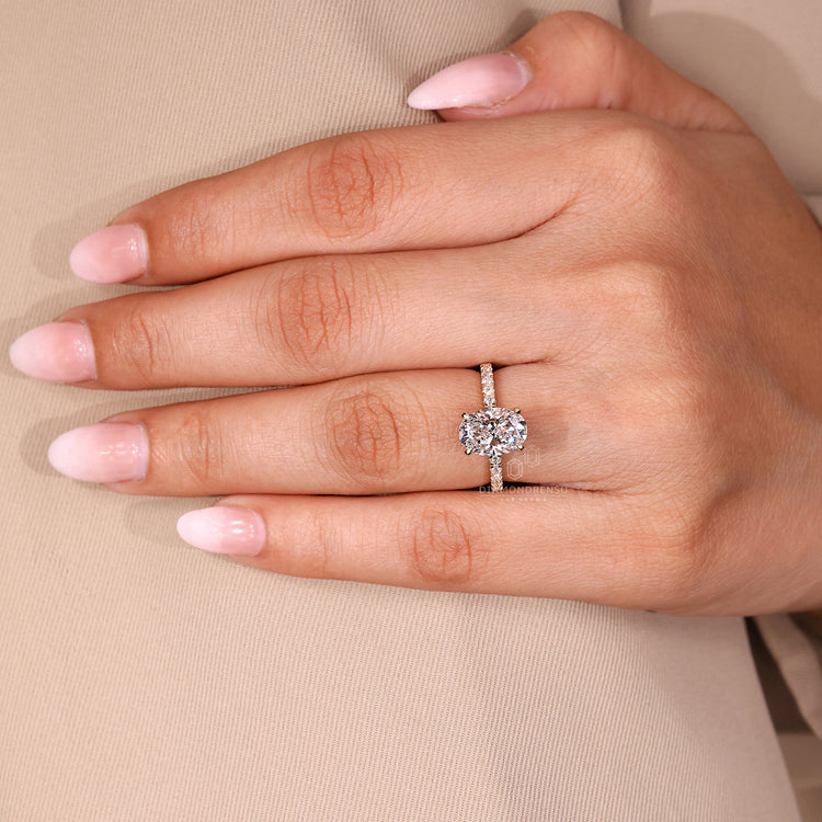 Oval cut ring with round cut pave band and four claw prong setting.