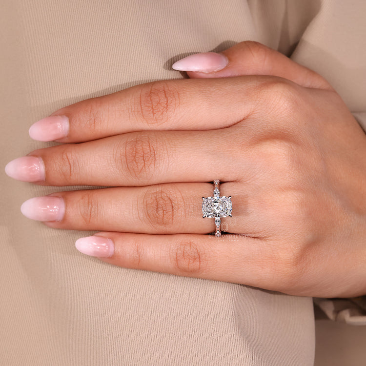 Elongated cushion cut diamond engagement ring with marquise and round pave.