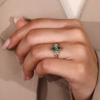 Green marquise diamond ring with round emerald gemstone details.
