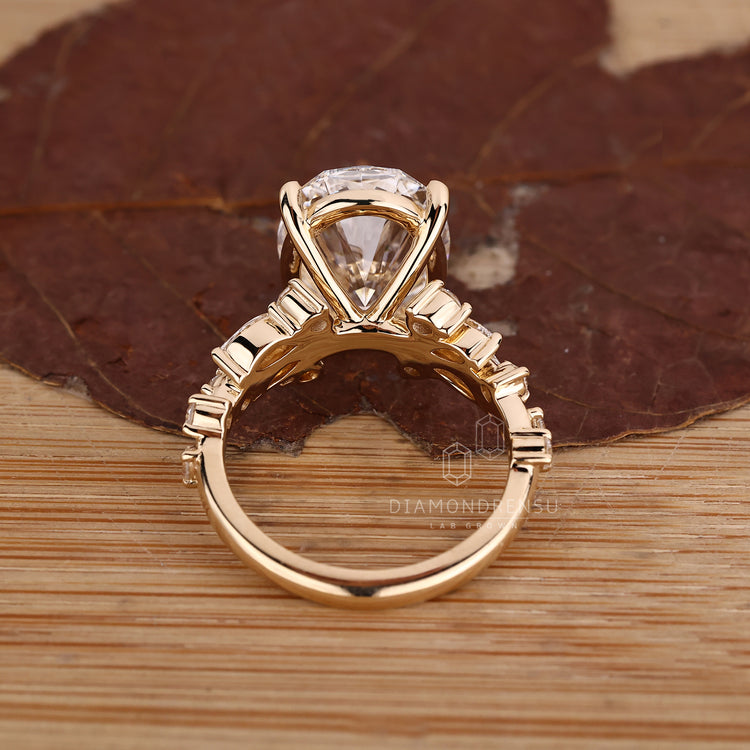 Four claw prong oval diamond ring in cluster design.
