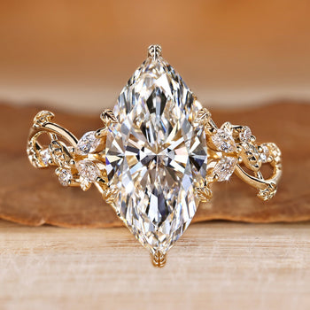 Marquise cut ring with marquise and round side stones and nature inspired style.