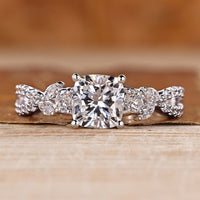 Trellis engagement ring with cushion center stone and marquise and round side stones.