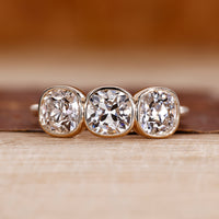Three stone ring with cushion old european cut diamond center.
