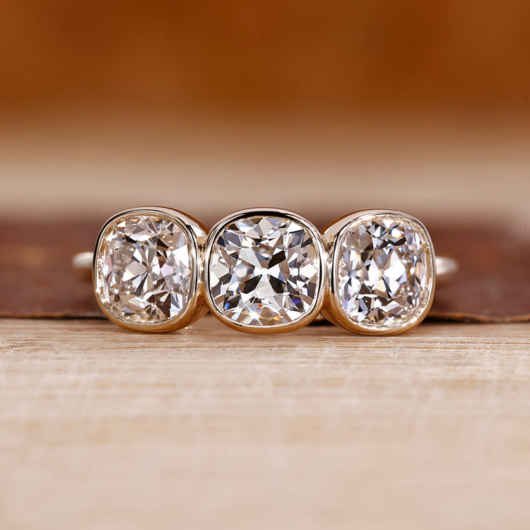 Three stone ring with cushion old european cut diamond center.
