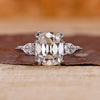 Cushion old mine cut center with pear cut side diamonds and knife edge shank.