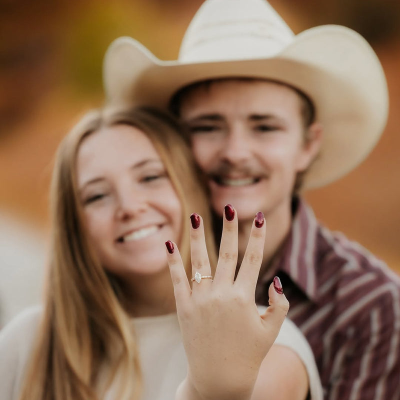 Smiling couple showing off an engagement ring