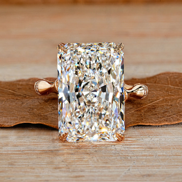 Radiant cut diamond ring with round diamond distance pave band.
