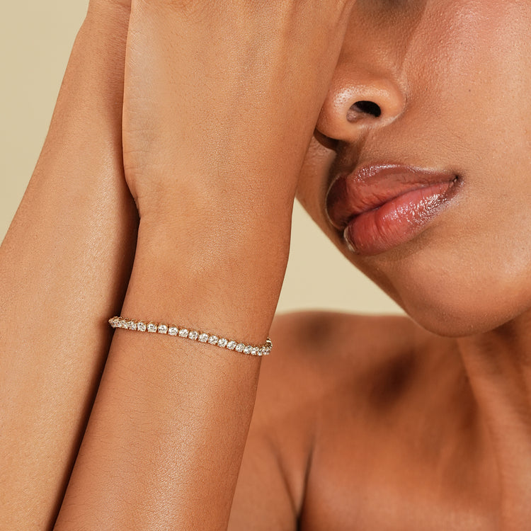 Yellow gold diamond tennis bracelet with round stones.
