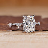 Handmade elongated cushion cut ring with distance pave and round cut accents.