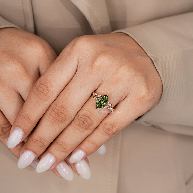 Green Dutch marquise engagement ring with a split shank and round side stones.