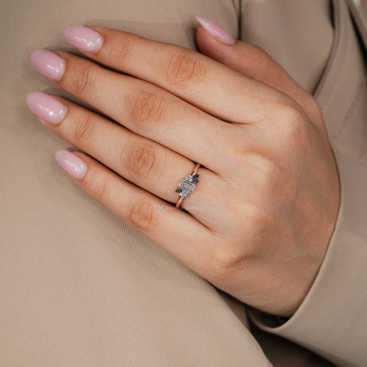 Lab grown diamond ring with an emerald center stone and blue sapphires.